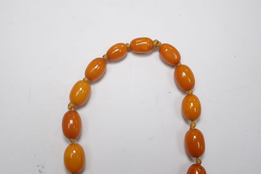 A single strand graduated oval amber bead necklace, 62cm, gross weight 34 grams. Condition - poor to fair